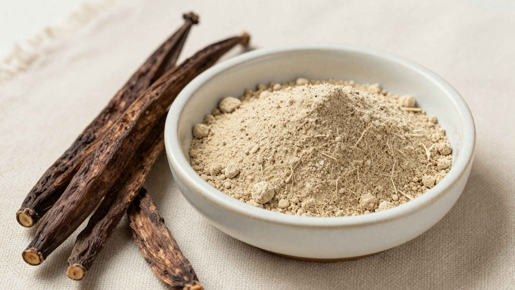 Maca root powder and dried maca roots in a ceramic bowl